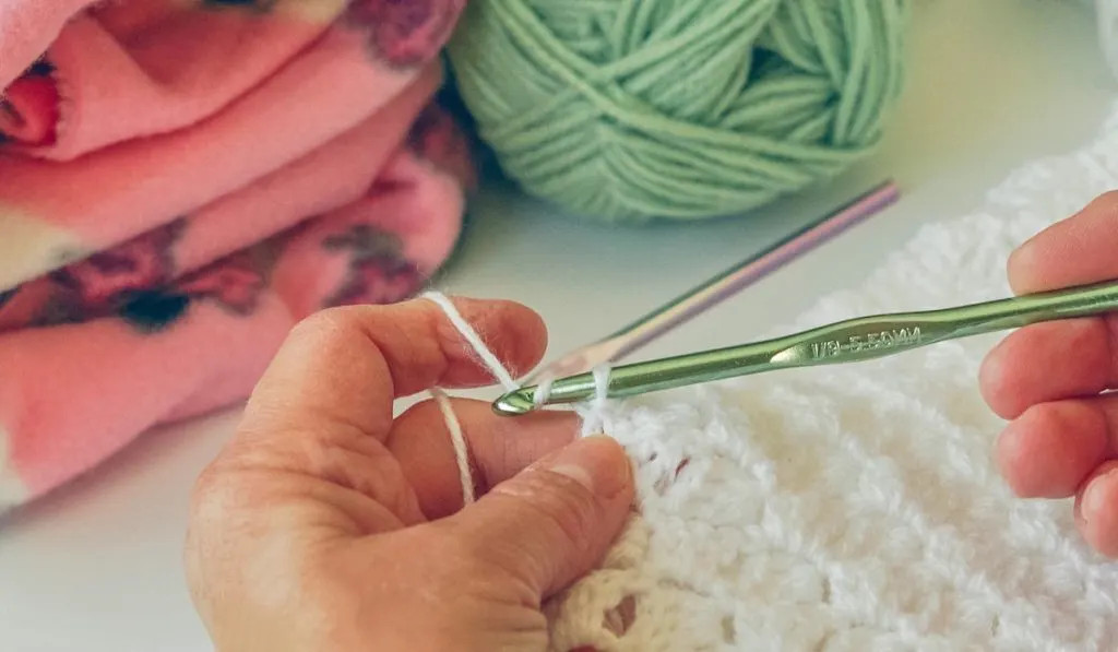 Closeup of hands crocheting a baby blanket