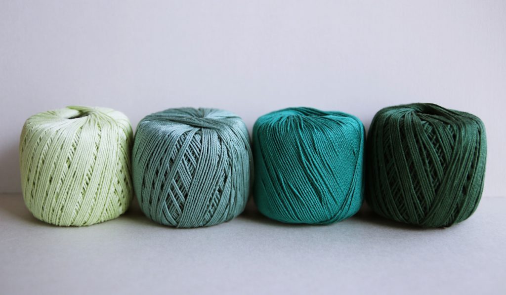 Crochet yarns, green tones on gray background