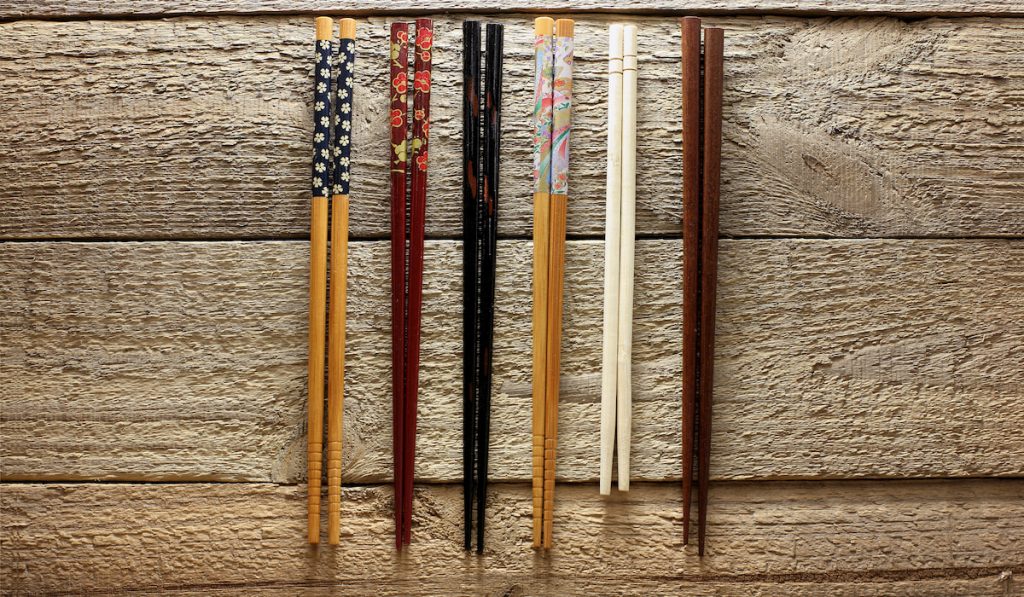 different design of chopsticks on wooden background