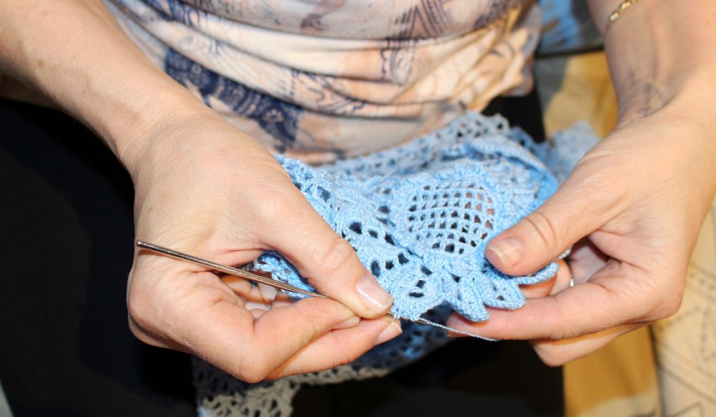 hand of woman finishing her crochet napkin