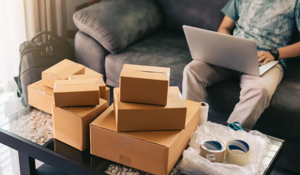 man going over inventory and shipping process of his products while at home