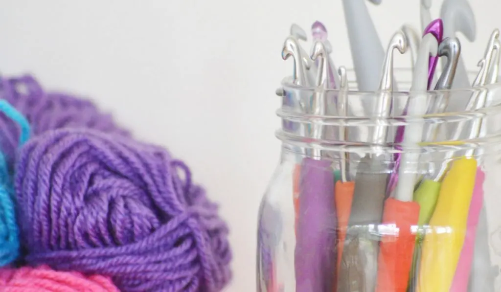 plastic hooks and yarn on white table 