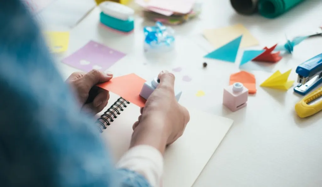 woman making her junk journal using recycled colorful papers