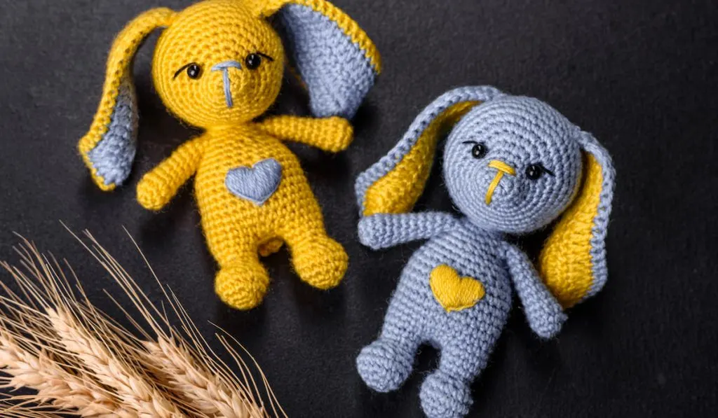 yellow and blue amigurumi toys on black background 