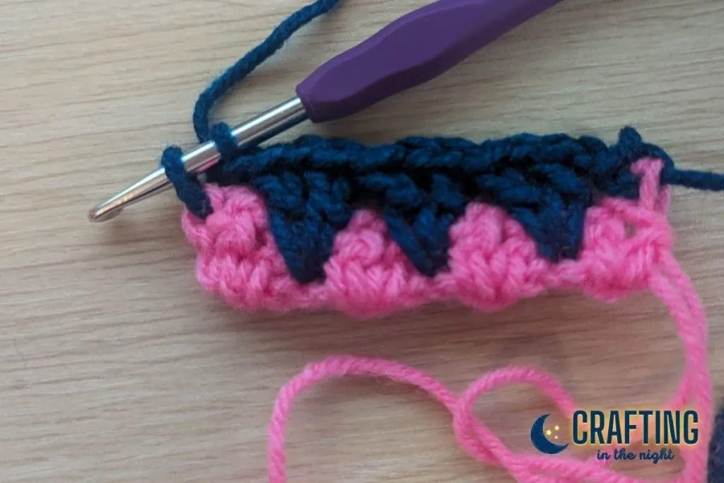 a crochet swatch showing a single crochet that has been started in the last stitch but not finished
