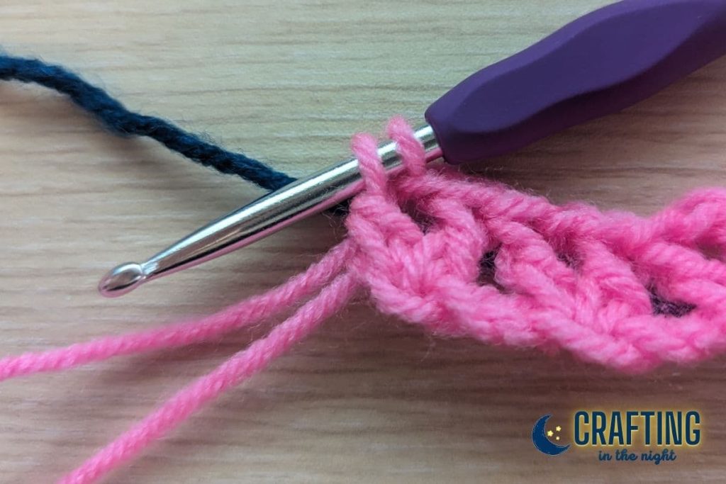 hot pink crochet swatch with a navy yarn laid behind it