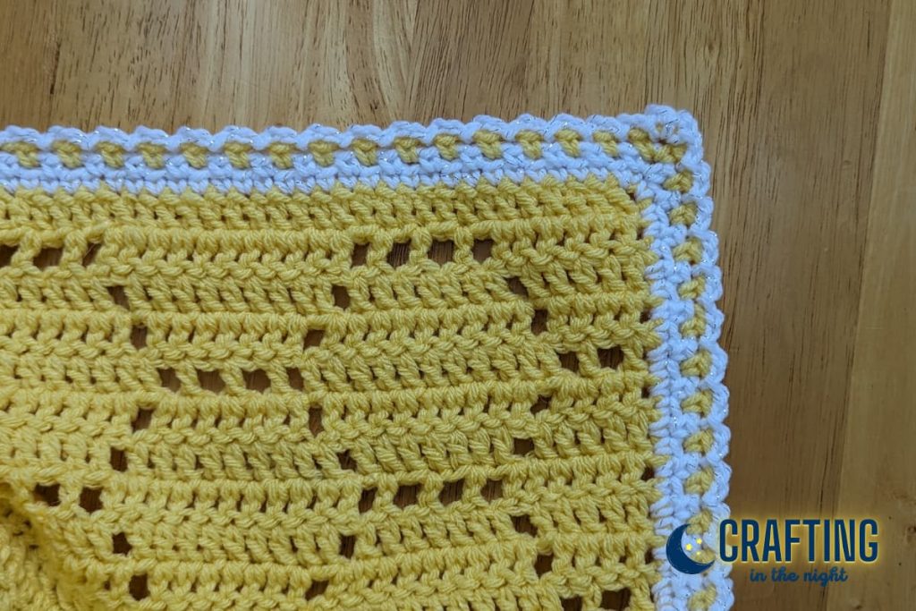 Crochet Blanket  yellow and white on wooden background
