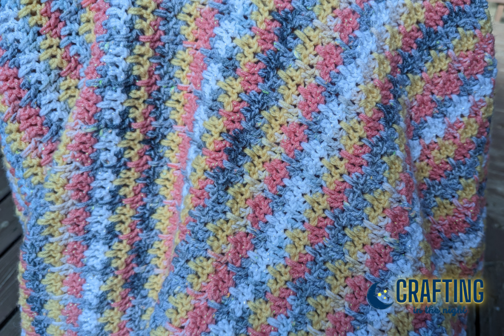 closeup of a crocheted blanket draped on a chair