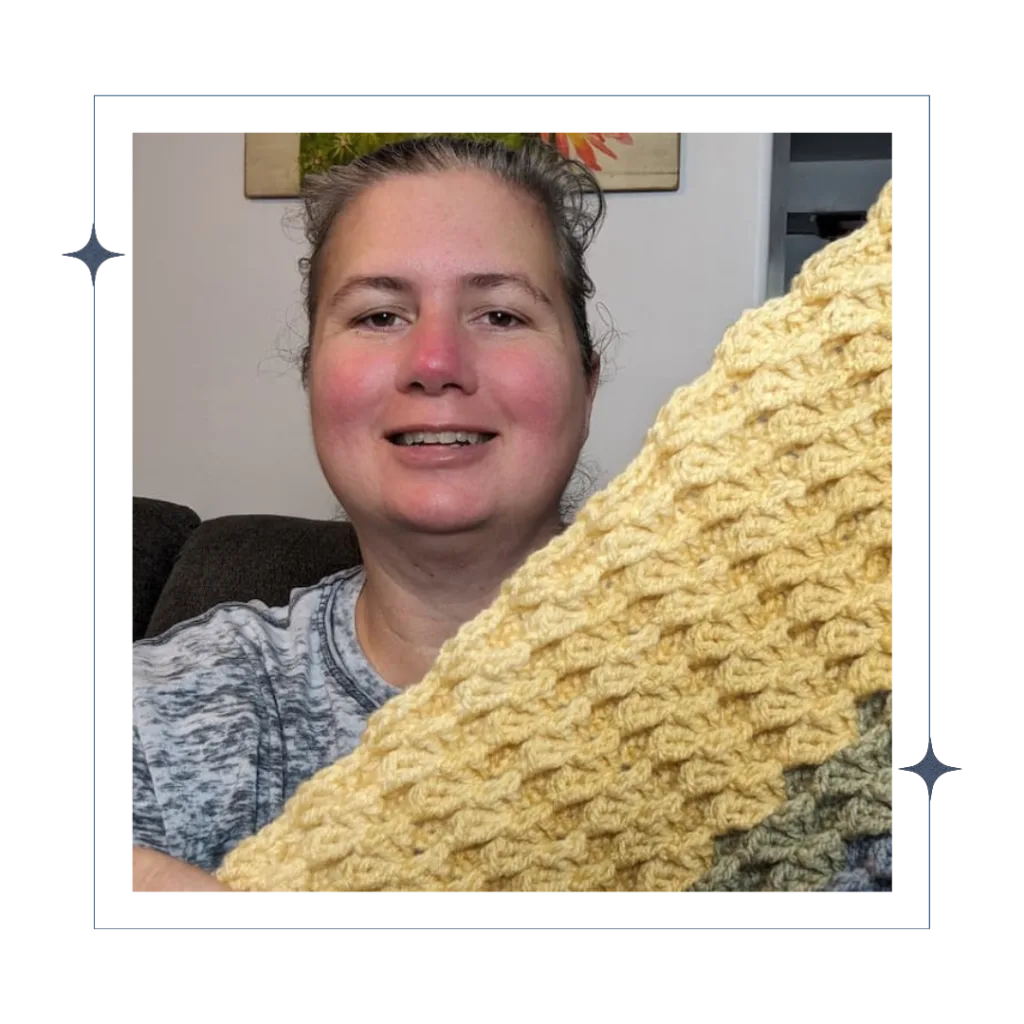 Portrait of April Lee holding up one of her crocheted creations.