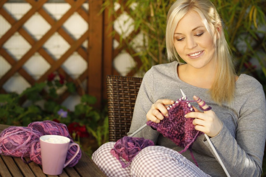 Woman knitting on terrace