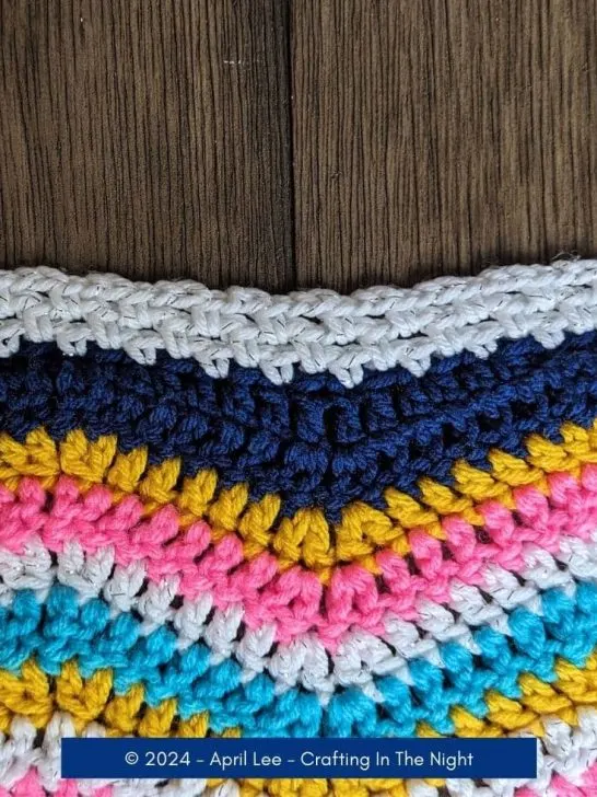 closeup of a simple crochet border placed on a rainbow wave afghan