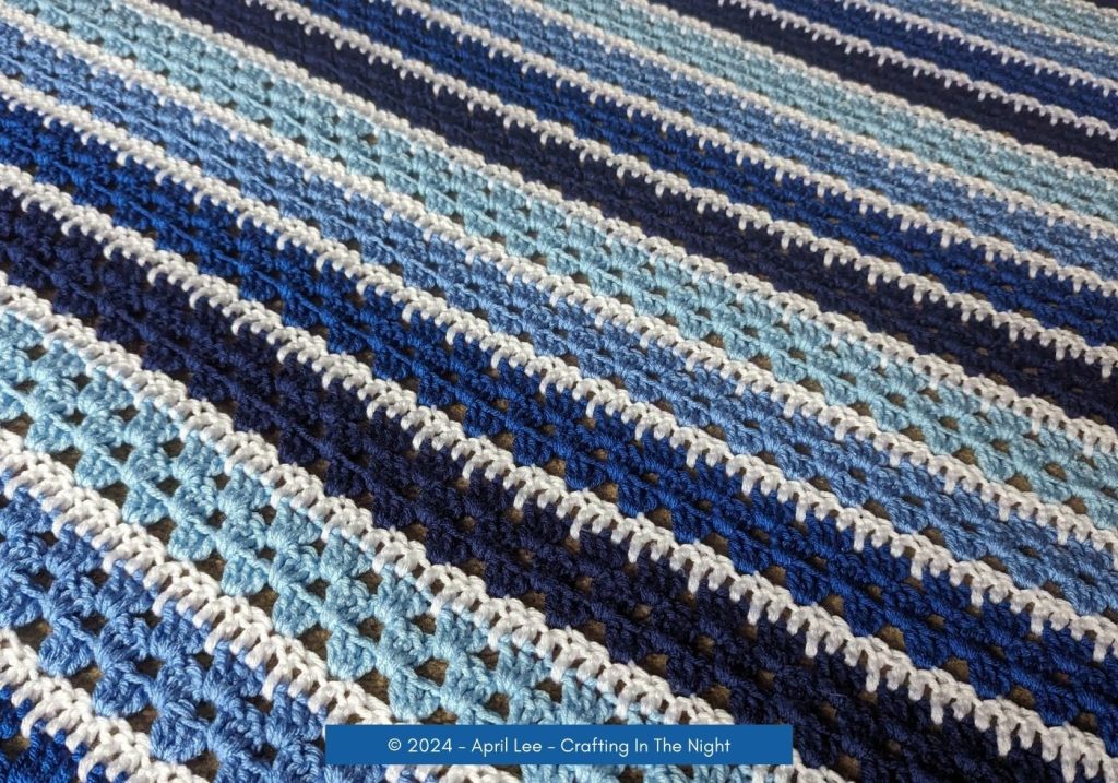Close-up view of Modern Granny Stripe Blanket blue spread out on the ground