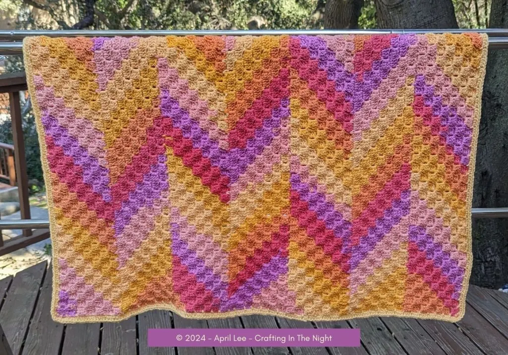 Sunset C2C blanket hanging over a clothes rack