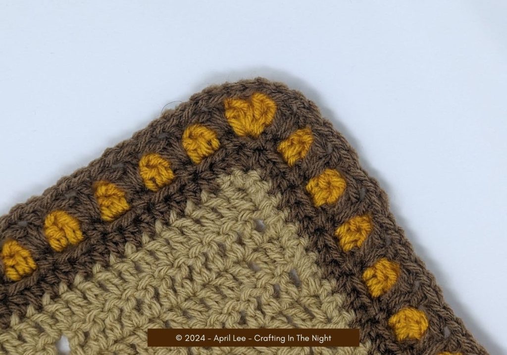 closeup of the corner of a moroccan tile stitch border in the colors gold and brown
